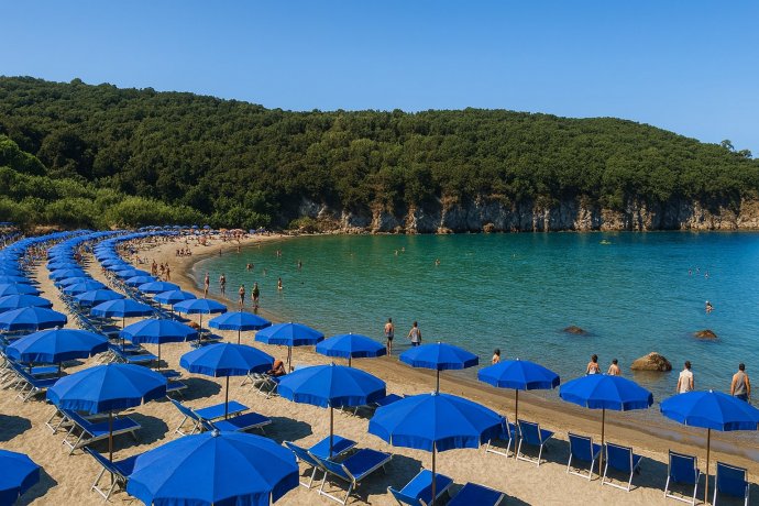 Ischia, Spiaggia di San Montano: baia riparata con ombrelloni blu, sabbia dorata e mare cristallino.