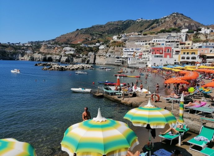 Spiaggia di Sant’Angelo d’Ischia con ombrelloni colorati e mare cristallino