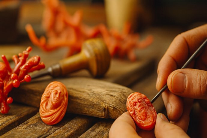 Mani di un artigiano scolpiscono un cammeo in corallo rosso a Torre del Greco, vicino Napoli.