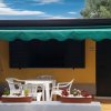 Casa gialla con veranda e tavolo.