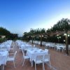 Ristorante all'aperto con tavoli bianchi apparecchiati.