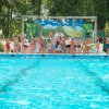 Persone su un palco vicino a una piscina durante un evento all'aperto.
