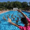 Istruttore guida gruppo di persone in una piscina all'aperto.